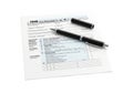 A black pen rests on a tax form document isolated on white background Royalty Free Stock Photo