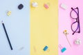 Black Pencil,Eraser,Paper Clips,Eyeglasses and White Flower on Pink,Yellow and Blue Background Royalty Free Stock Photo