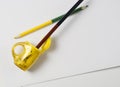 black pencil inserted into a yellow sharpener on a white sheet. Royalty Free Stock Photo
