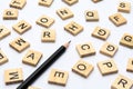 Black pencil and scattered alphabet letters on wooden blocks on white background Royalty Free Stock Photo