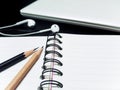 Black pencil and wooden pencil and book and laptop hoop on the teble Royalty Free Stock Photo