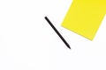 Black pencil and a yellow Notepad on a white background. Minimal concept workspace. Royalty Free Stock Photo