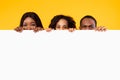 Black people peeking out blank white advertising billboard at studio Royalty Free Stock Photo