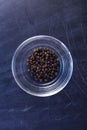 Black pepper in bowl on black background Royalty Free Stock Photo