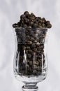 Black pepper in glass with white background