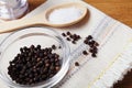 black pepper peas in a glass bowl on a linen napkin, salt mill on a wooden kitchen table Royalty Free Stock Photo