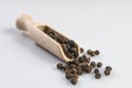 Black pepper peppercorns in wooden scoop isolated on white background Royalty Free Stock Photo