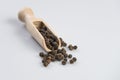 Black pepper peppercorns in wooden scoop isolated on white background Royalty Free Stock Photo