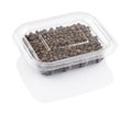 Black pepper seeds in a transparent plastic container Royalty Free Stock Photo