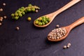 Black pepper spice peppercorn on wooden spoon and dark rustic background
