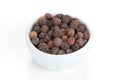Black pepper in a white bowl on white background. Royalty Free Stock Photo