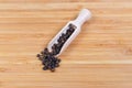 Black pepper in the wooden spice spoon and beside