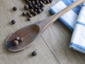 Black pepper on wooden spoon and dishcloths Royalty Free Stock Photo