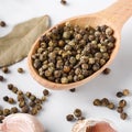 Black pepper in wooden spoon with garlic and bay leaves Royalty Free Stock Photo