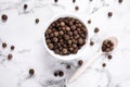 Black peppercorns on white marble table Royalty Free Stock Photo