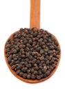 Black peppers on a wooden spoon