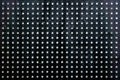 Black perforated steel sheet with round holes, close-up