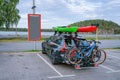 Black personal car with two mounted mountain bicycles at back side and two kayaks at top. Green and red kayaks. Royalty Free Stock Photo