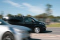 The black Peugeot Traveler is driving down the street in heavy traffic. Motion blur. Riga, Latvia - 15 Jun 2021