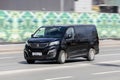 Black Peugeot Traveller passenger van in fast motion on city street. Fast moving minibus car on urban road Royalty Free Stock Photo