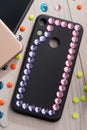 Black phone case decorated with pink rhinestone frame