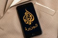 Black phone with logo of news media Al Jazeera on the screen. Royalty Free Stock Photo