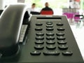 Black phone on the table on blurred people background, .Modern technology in communication Royalty Free Stock Photo