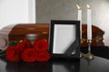 Black photo frame with burning candles and red roses on table Royalty Free Stock Photo