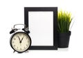 Black photo frame and clock isolated on white background, plant behind Royalty Free Stock Photo