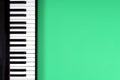 Black piano keyboard on light green background. Music learning concept. Top view Royalty Free Stock Photo