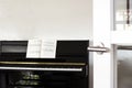 A black piano in a modern white living room with music sheets Royalty Free Stock Photo