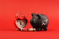 Black piggy bank with white heart and heart alarm clock and gift of money american hundred dollar bills with red ribb