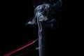 A black and pink colored pencil touching the white smoke coming from below Royalty Free Stock Photo