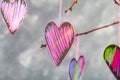 Black-pink hearts hang on branches on a gray concrete background. Love tree. The concept of Valentine's Day. A symbol of love. Royalty Free Stock Photo