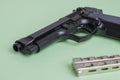 Black pistol and iron knife on a light green background Royalty Free Stock Photo
