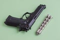 Black pistol and iron knife on a light green background Royalty Free Stock Photo