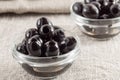 Black pitted marinated olives in a glass cup