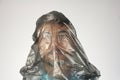 Black plastic bag on human head, gray background, concept big ecology problem, copy space