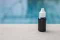 Black plastic bottle over blurred blue swimming pool water Royalty Free Stock Photo