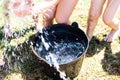 Black plastic bucket with fresh water with many kids legs playing summer games Royalty Free Stock Photo