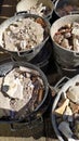 Black plastic buckets full of rubble seen from above. remains of walls