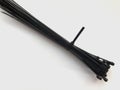 Black plastic cable ties. Plastic clamps on a white background. Industrial