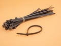 Black plastic cable ties on an orange background. Royalty Free Stock Photo