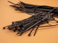 Black plastic cable ties on an orange background. Royalty Free Stock Photo