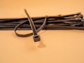 Black plastic cable ties on an orange background. Royalty Free Stock Photo