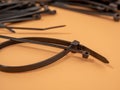 Black plastic cable ties on an orange background. Royalty Free Stock Photo