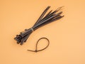 Black plastic cable ties on an orange background. Royalty Free Stock Photo