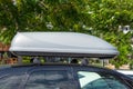 Black plastic car rooftop cargo box or roof carrier for traveling. Removable storage container mounted on car roof rack Royalty Free Stock Photo