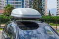 Black plastic car rooftop cargo box or roof carrier for traveling. Removable storage container mounted on car roof rack Royalty Free Stock Photo