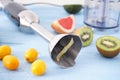 Black plastic electrical hand blender and accessories with sliced fruit on blue wooden background. Close up Royalty Free Stock Photo